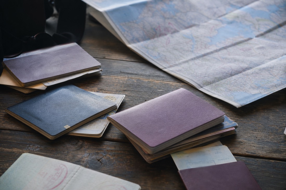 Family travel documents and passports arranged on a table beside a folded map