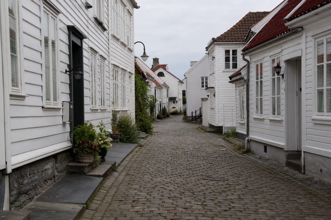 Quiet cobbled street of white wooden houses in a Norwegian old town