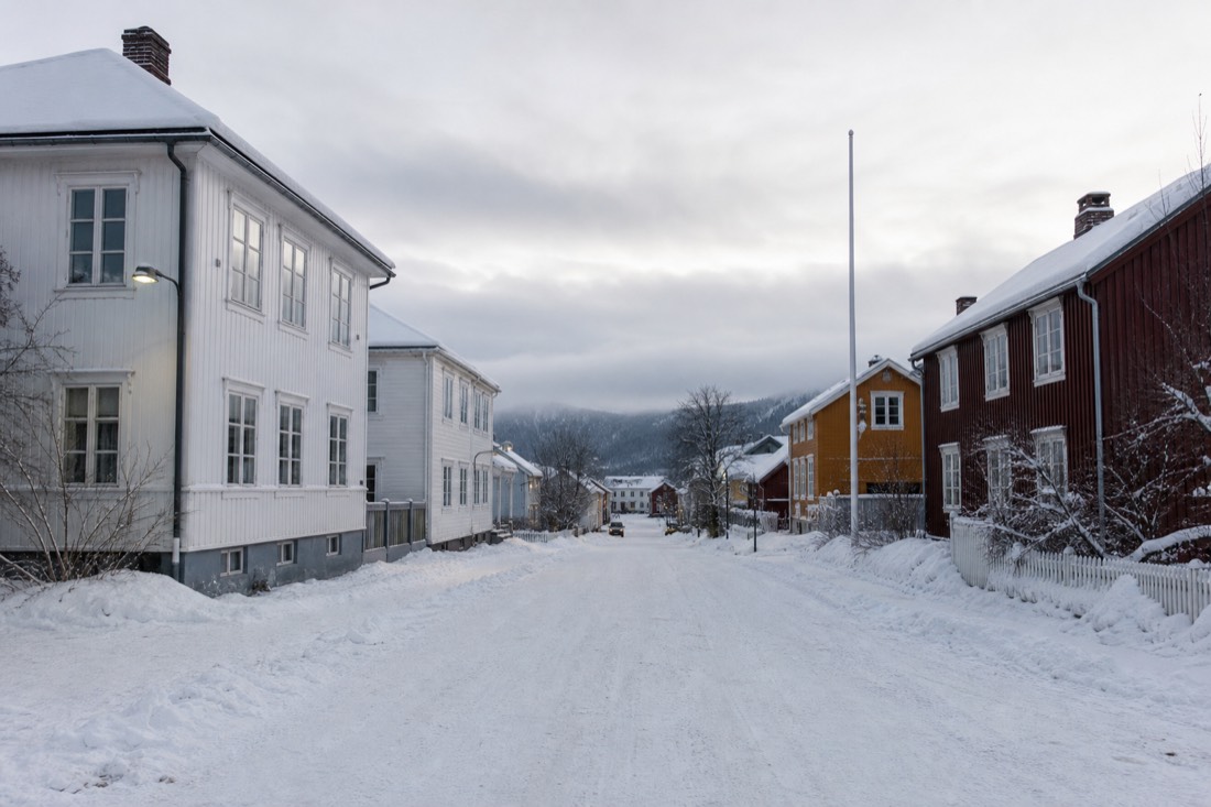 Snow-covered wooden houses along a wide street in an inland Norwegian town