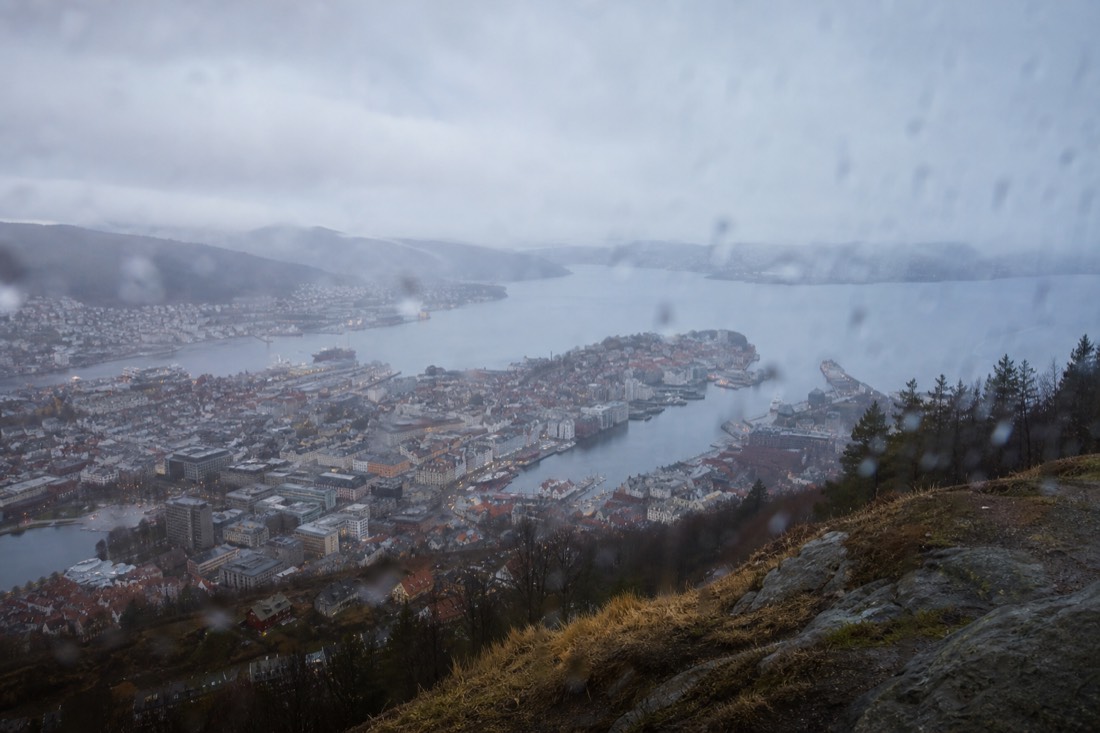 View over Bergen rooftops from Floyen with low cloud sitting on the surrounding hills and rain on the lens