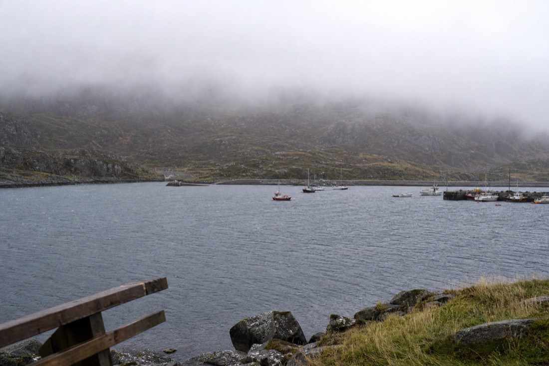 Fine rain blowing across a harbour with low cloud on the hills behind