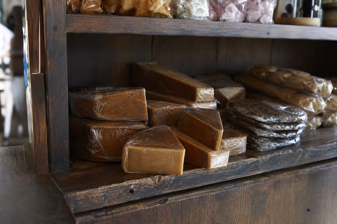 Wrapped blocks of brown cheese and packaged goods on a shop shelf