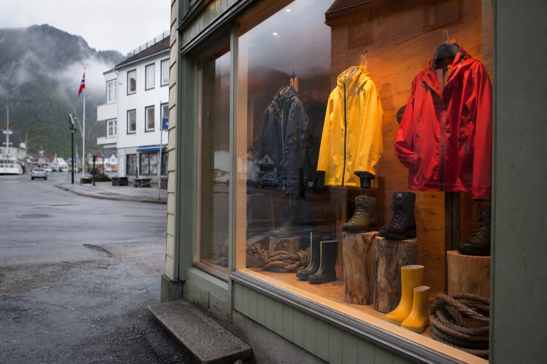 Outdoor shop window display of waterproof jackets and boots on a Norwegian street