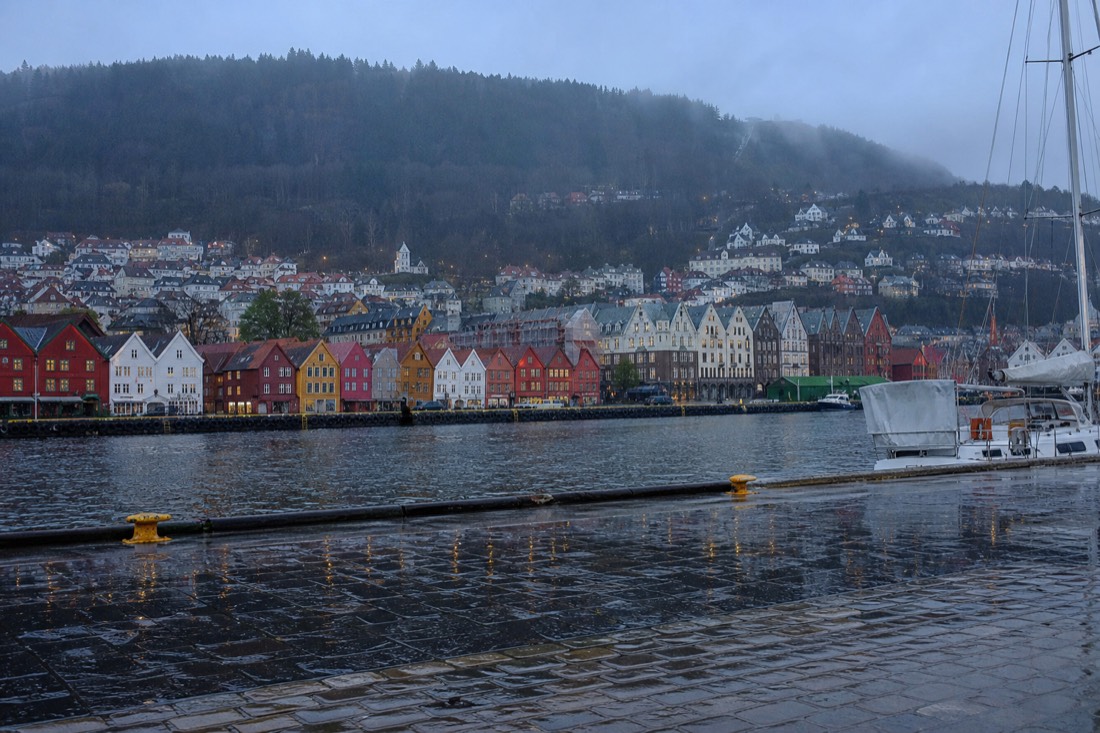 Rain falling on Bergen harbour with reflections of coloured wooden buildings in the wet quay