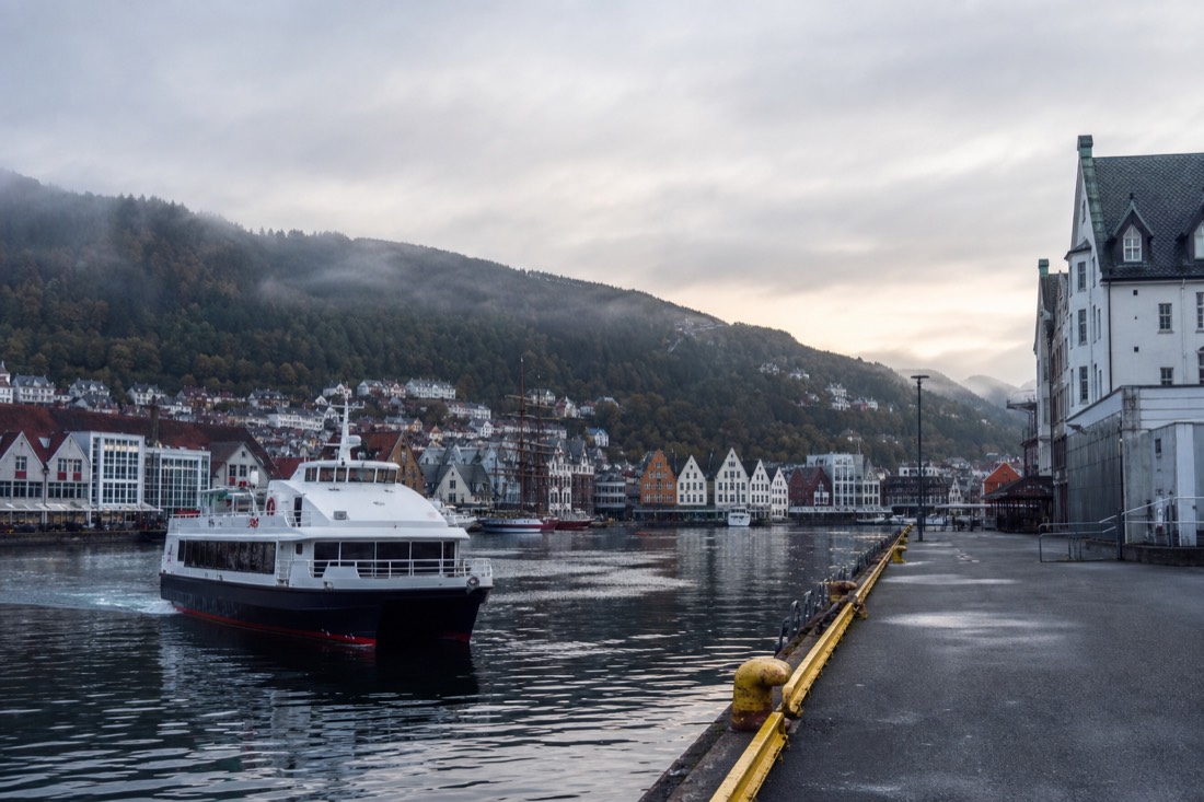 Bergen harbour early in the morning with a cruise boat preparing to leave and empty quaysides