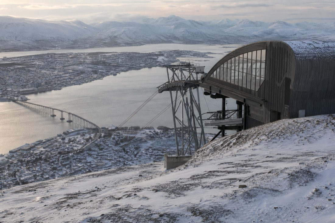 Fjellheisen cable car station above Tromso with the city and bridge visible below in winter light